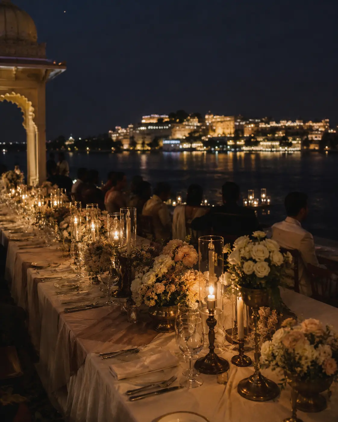 Candlelit welcome dinner beside the lake at dusk